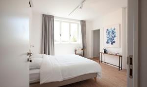 亨克Le Charbonnage的白色的卧室设有一张大床和一个窗户