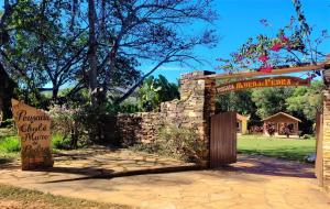圣托梅-达斯莱特拉斯Pousada Muro de Pedra的花园入口,带石墙和标志