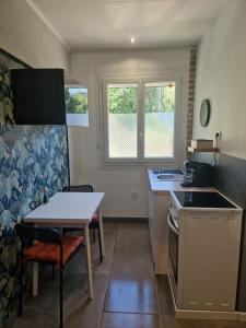 塞雷赞迪罗纳Appartement indépendant dans maison avec jardinet, au calme的厨房配有桌子和桌椅