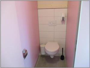 德兰斯克Baumzeltdorf OSTSEEBREEZE direkt am Strand的一间带卫生间和粉红色墙壁的浴室