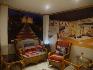 卢克索Venus hotel luxor 日本人 大歓迎的一间设有两把椅子的房间和墙上的一幅画