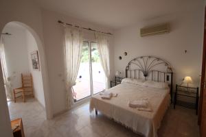 莫莱拉Sesam - sea view villa with private pool in Moraira的一间卧室设有一张床,并有通往庭院的门