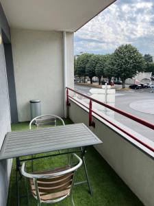 永河畔拉罗什Charmant appartement la Roche sur Yon的阳台上配有野餐桌和两把椅子