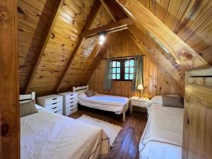 莫雷诺Los Plátanos cabañas & suites的小木屋内一间卧室,配有两张床