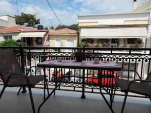 扎金索斯镇Vera City Apartment的阳台的桌子,配有椅子和围栏