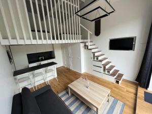 奈达Alyvų Namai Nida的客厅设有楼梯和桌子