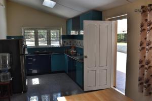 桑提科帕Rochas Valley Homestay的厨房配有蓝色橱柜和白色门