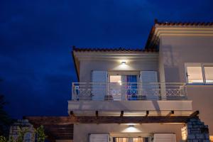 纳夫普利翁Villa San Adriano的白色房子,晚上设有阳台