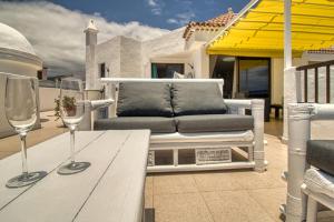 法纳贝海滩Luxury Penthouse Sea View Jacuzzy & pool wiffi free的天井上的桌子和两杯酒杯