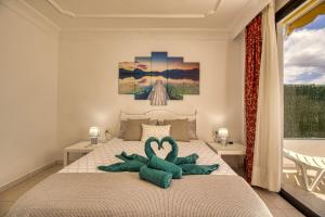 法纳贝海滩Luxury Penthouse Sea View Jacuzzy & pool wiffi free的一间卧室配有一张带两个天鹅的床