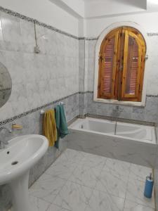 卢克索Gabawy Garden Ferienwohnung的白色的浴室设有浴缸和水槽。