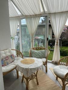 萨拉热窝Downtown House with garden的客厅配有桌椅和窗户。