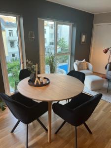 卑尔根Modern Apartment - Amazing Terrace and Fjord View, Close to City Center的客厅配有木桌和椅子
