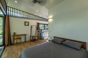萨玛拉Nangu lodge的一间卧室配有一张床铺和一张桌子,还设有一间厨房