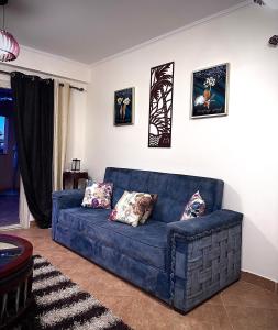 艾因苏赫纳Telal Al Sukhna Only families的客厅里一张蓝色的沙发,墙上挂着照片