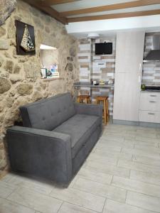VilarA CASIÑA DA PALMERA的带沙发和石墙的客厅