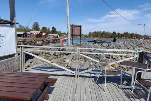 HolmsundGästhus nära naturen的木甲板上设有长凳和围栏