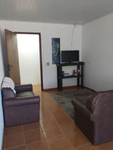 因比图巴POUSADA DA PONTE IBIRAQUERA的客厅配有两张沙发和一台电视