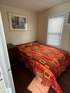 希塞德高地Shore Beach Houses - 43A Lincoln Ave的一间卧室配有一张带红色棉被的床和窗户。