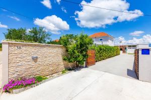 VisočaneKristina holiday home with private swimmingpool的砖墙和车道的房子