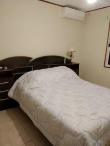 梅塞德斯La Solita的卧室配有白色的床和书桌