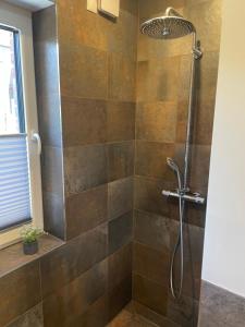 布劳恩拉格Eastside Braunlage的浴室设有棕色瓷砖和淋浴。