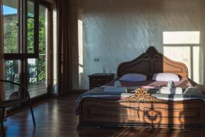 马钦加里Batumi Homestay at Tamar Mephe Avenue的一间卧室配有一张大床和木制床头板