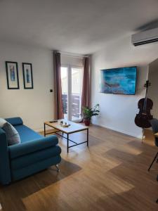 卡什泰拉Apartman LIBRA的客厅配有蓝色的沙发和桌子