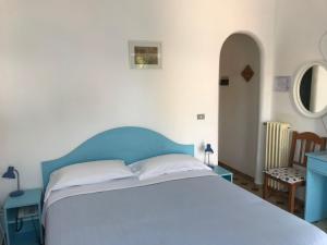 伊斯基亚安东尼别墅酒店的卧室配有蓝色和白色的床和一张桌子