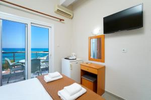 利迈纳里亚Hotel Papageorgiou的一间卧室设有一张带电视的床和一个阳台。