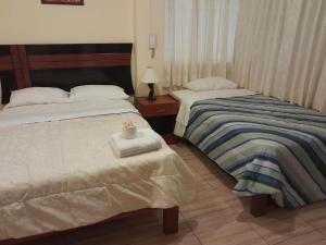 巴兰卡HOTEL CASTILLO MAGICO (EX CHAVIN SEÑORIAL?的两张睡床彼此相邻,位于一个房间里