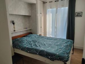 Saint-Georges-sur-BaulcheMaison avec jardin Auxerre的一间卧室配有一张带蓝色棉被的床和窗户。
