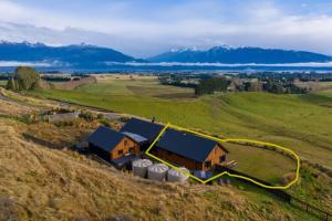 蒂阿瑙Fiordland Eco-Retreat -- Panoramic Views -- Hot Tub的山丘上房屋的空中景致