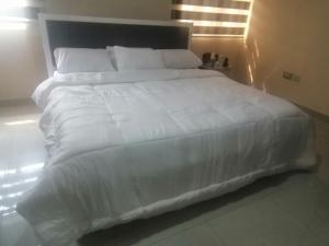 哈科特港Luxury Homes的一张白色大床,配有白色床单和枕头