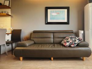 济州市Aewol Bada Poomeun Property的客厅里配有带枕头的棕色沙发