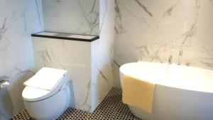 乔治市乔治酒店的浴室配有盥洗盆、卫生间和浴缸。