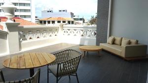 乔治市乔治酒店的阳台配有沙发和桌椅。