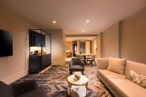 墨尔本Dorsett Melbourne的客厅配有沙发和桌子