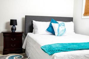 Exuma Harbour EstatesSheer Bliss BeachView Apt #2的一张带蓝色和白色枕头的床和床头柜