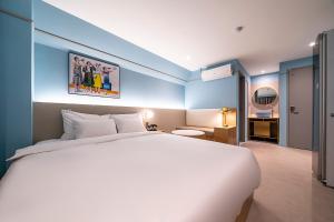 原州市Wonju Hotel Ippda的卧室配有白色大床和蓝色的墙壁