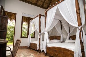比亚维森西奥Hotel Reserva de Piedemonte的卧室配有带白色窗帘的天蓬床