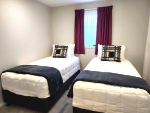 惠灵顿U Suites on Rongotai Rd的一间卧室设有两张床和窗户。