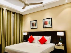 WatumullaTropic Inn - Mount Lavinia的配有红色枕头的床的酒店客房