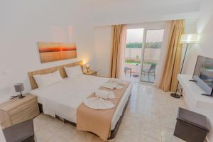 帕拉代西翁Viva Tourismo Resort (naturist club)的卧室配有一张白色大床和电视。