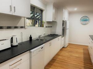 埃斯佩兰斯Blue Tides Accommodation的厨房配有白色橱柜和黑色台面