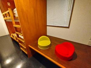 东京plat hostel keikyu asakusa karin的一间桌子上放着两个红色和黄色碗的房间