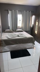 坦加拉-达塞拉Tangará da Serra的卧室设有床和窗户,铺有白色地板。