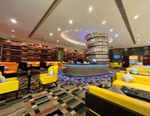 上海上海大宁福朋喜来登酒店的酒店大堂设有黄色椅子和葡萄酒桶