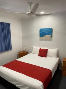 约克斯诺波纽约海滨假日公寓酒店的一间卧室配有一张带红色毯子的大床
