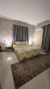 艾卜哈ليلك lilac的一间卧室配有一张带窗帘和地毯的床